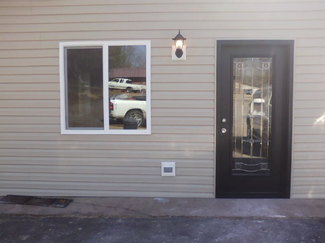 New siding, window and entry door on the side of an addition in Byron